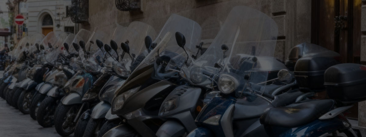 Row of parked scooters lined up along a street