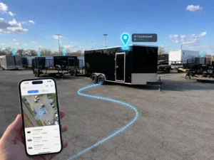 Smartphone app tracking enclosed trailers in a lot, with a highlighted trailer location marked on the screen