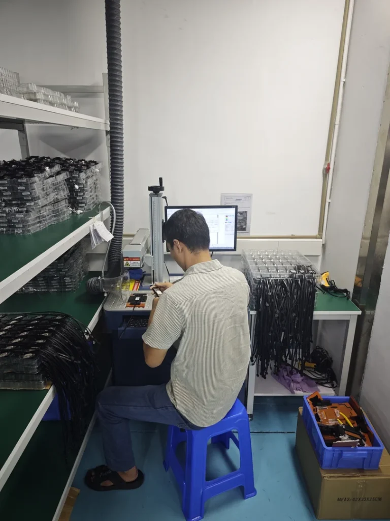 Worker inspecting eyeglass frames at a workstation in a factory