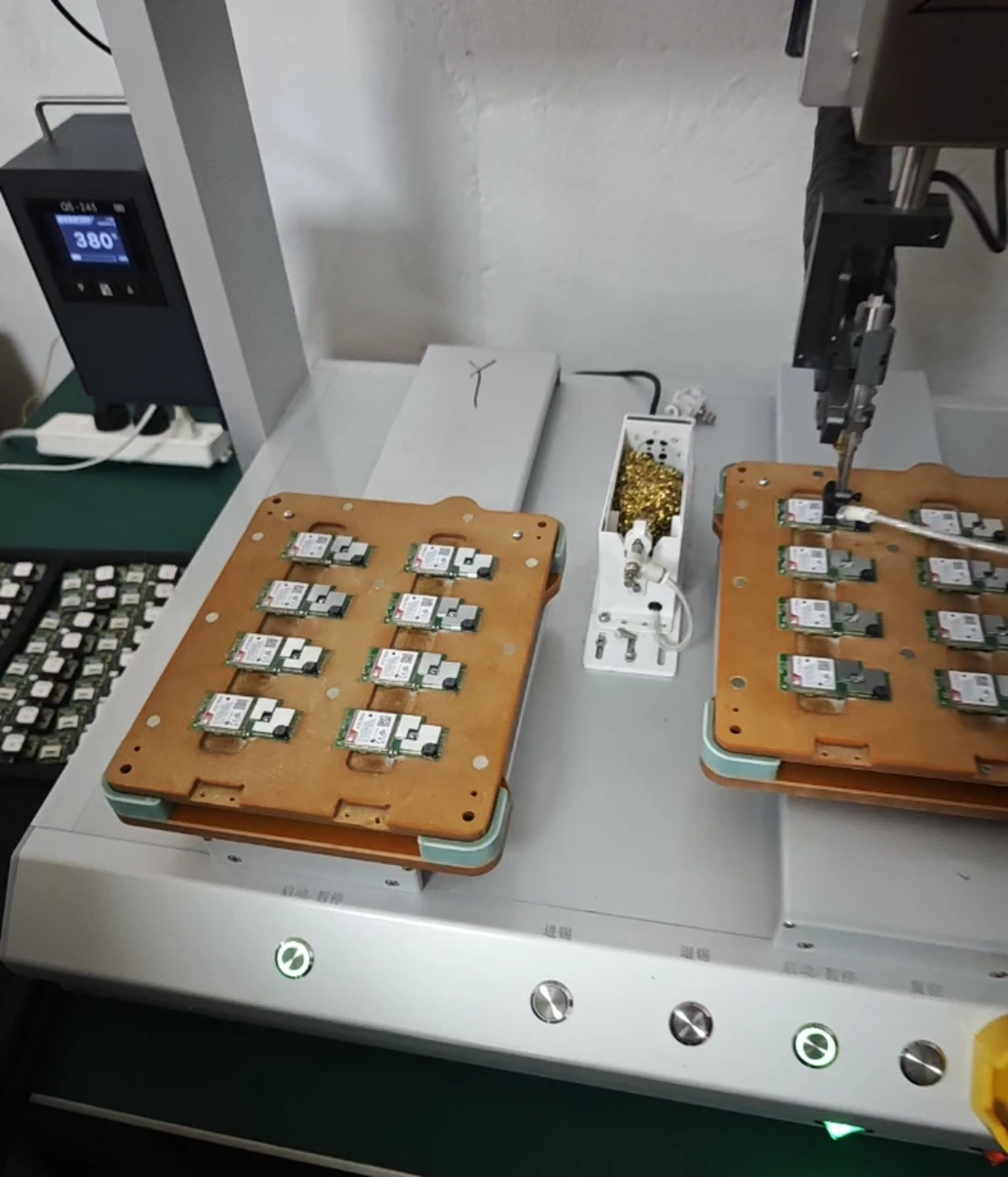 Circuit boards mounted on fixtures in an automated assembly machine on a factory workstation