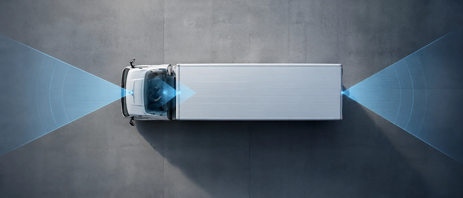 Overhead view of a white truck with blue beams illustrating sensor detection zones at the front, center, and rear