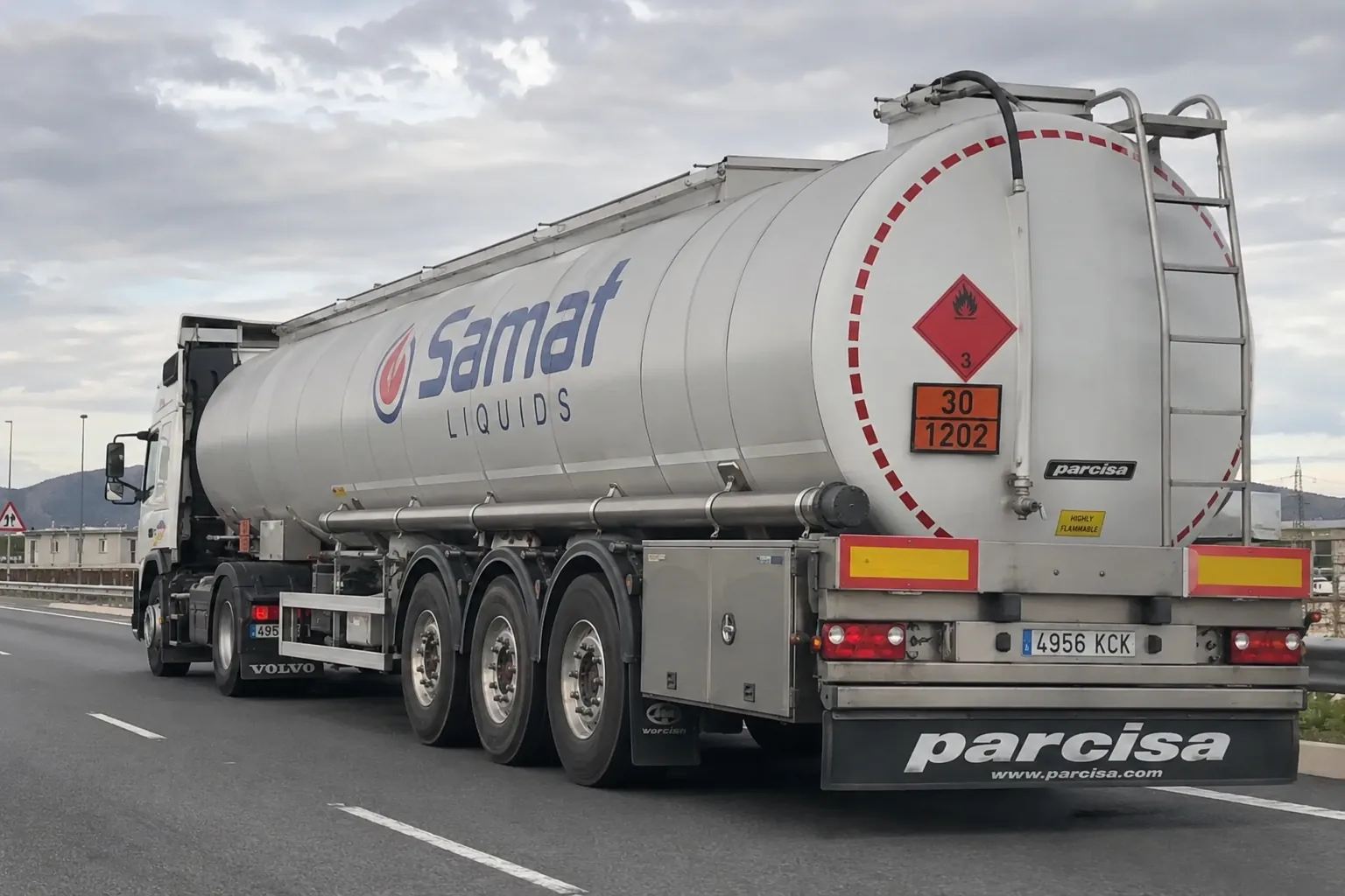 White fuel tanker truck on a highway, marked as flammable cargo and branded Samaf Liquids