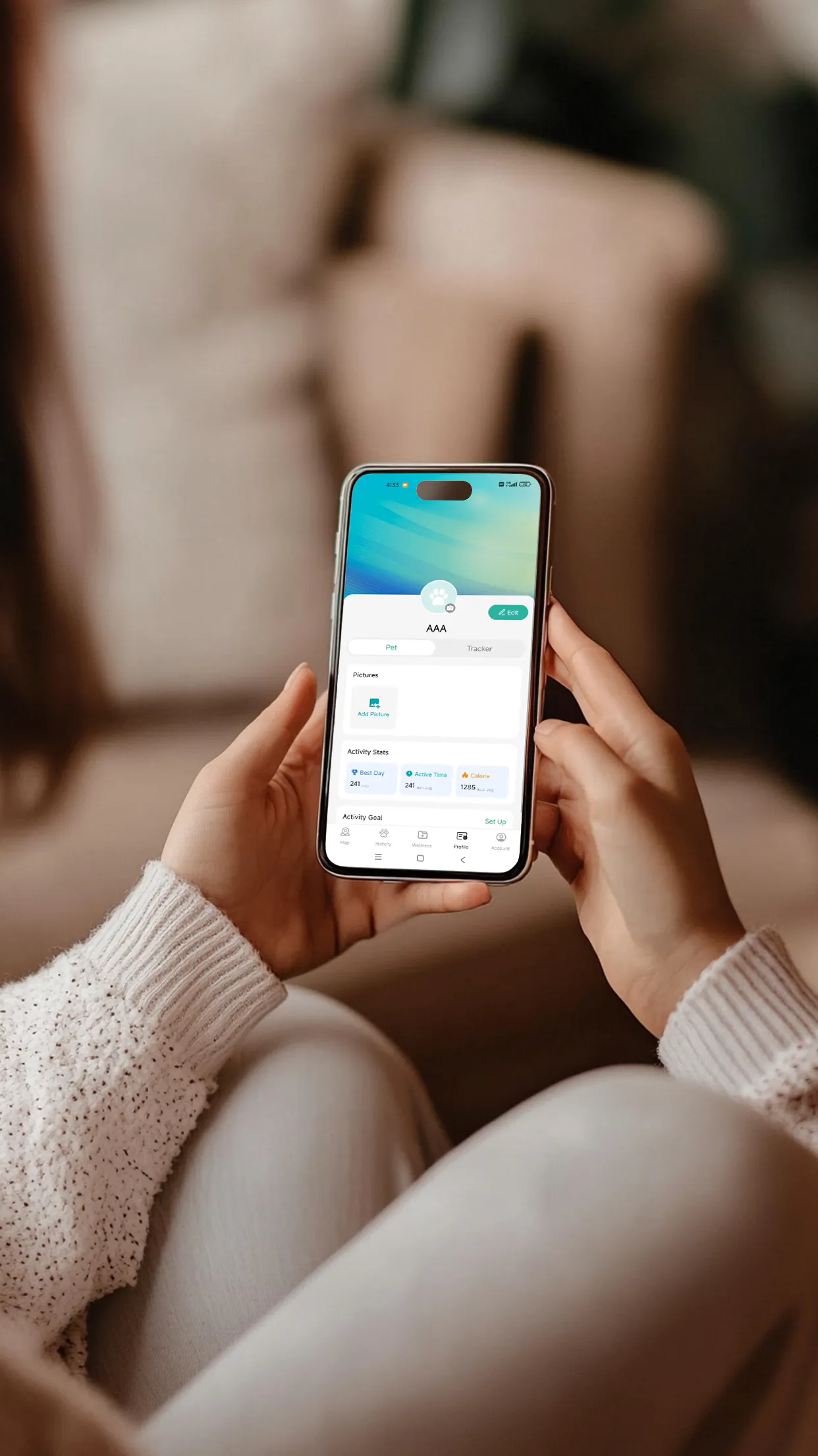 Person holding a smartphone displaying a pet activity-tracking app profile